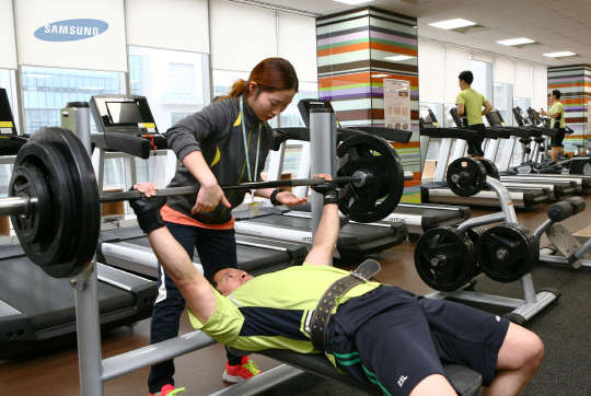 지난 14일 삼성디스플레이 아산사업장에서 근무하는 한 직원이 점심시간을 이용해 사내 피트니스센터에서 전문강사의 코칭을 받으며 운동하고 있다.  삼성디스플레이 제공